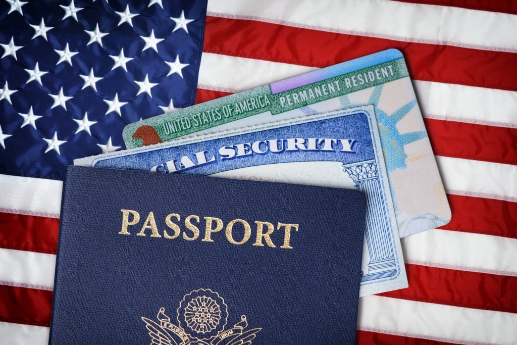 United States passport, social security card and resident card over american flag