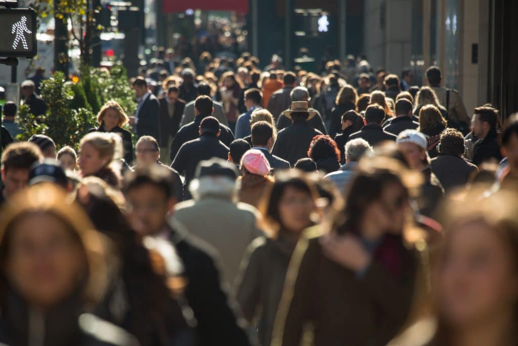 Crowd of anonymous people walking on busy street