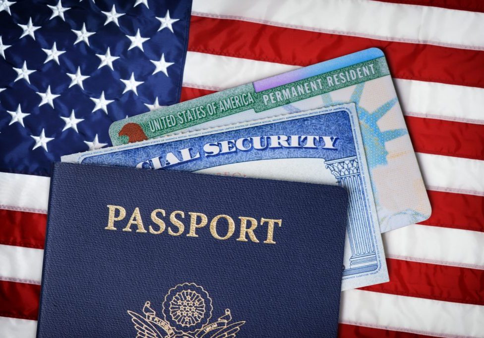 United States passport, social security card and resident card over american flag