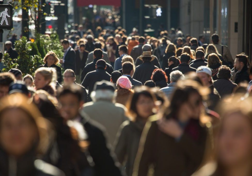 Crowd of anonymous people walking on busy street